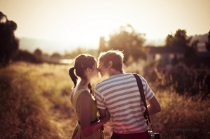 Молодая пара целуется в лучах солнца